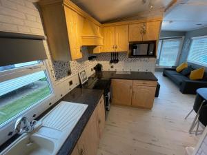 a kitchen and living room with a couch in a caravan at Reighton Sands 2 in Filey