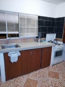 a kitchen with a sink and a stove at Los Tamarindos Posadamanabita in Portoviejo