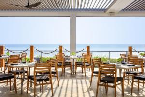 ein Restaurant mit Tischen und Stühlen mit Meerblick im Hintergrund in der Unterkunft Kimpton Vero Beach Hotel & Spa, an IHG Hotel in Vero Beach