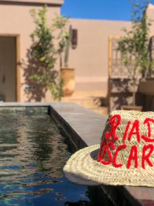 a straw hat sitting next to a swimming pool at Riad Oscaroi in Marrakesh