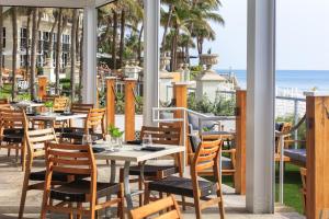 - un restaurant avec des tables et des chaises donnant sur l'océan en arrière-plan dans l'établissement Kimpton Vero Beach Hotel & Spa, an IHG Hotel, à Vero Beach