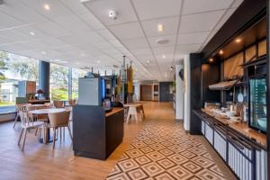 a restaurant with a counter and tables and chairs at B&B HOTEL Paris Créteil in Créteil