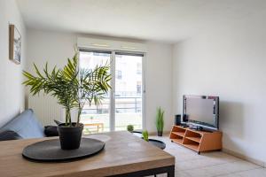 a living room with a potted plant on a table at Le Zénith - GOLDEN TREE - Parking privé & WIFI - 5 min Zénith de Strasbourg in Strasbourg