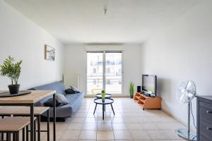 a living room with a blue couch and a tv at Le Zénith - GOLDEN TREE - Parking privé & WIFI - 5 min Zénith de Strasbourg in Strasbourg