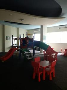 een speelkamer met een glijbaan en tafels en stoelen bij KLCC Putri YKS 7pax Kuala Lumpur in Kuala Lumpur