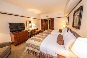 a hotel room with a large bed and a flat screen tv at Alyeska Resort in Girdwood