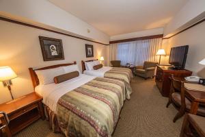 a hotel room with two beds and a television at Alyeska Resort in Girdwood