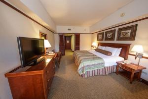 a hotel room with a bed and a flat screen tv at Alyeska Resort in Girdwood