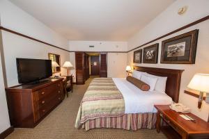 a hotel room with a bed and a flat screen tv at Alyeska Resort in Girdwood