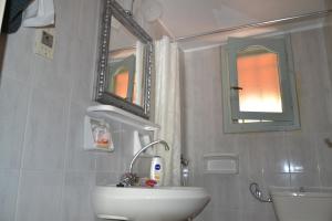 a white bathroom with a sink and a mirror at Mihaila seaside: 2 bedroom bungalows Kefalonia in Spartia