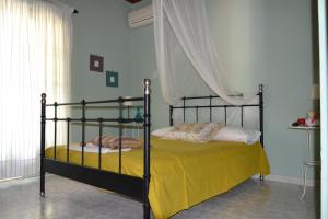 a bedroom with a bed with a yellow blanket at Mihaila seaside: 2 bedroom bungalows Kefalonia in Spartia