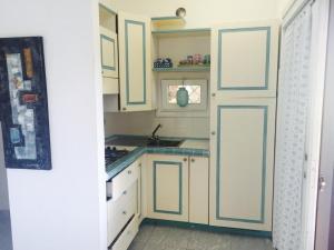a kitchen with green and white cabinets and a sink at Villa con vista sull’arcipelago della Maddalena in Palau