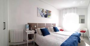1 dormitorio con 1 cama grande con almohadas azules en Precioso apartamento en Plentzia, en Plentzia