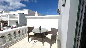 a patio with a table and chairs on a balcony at Casa Zen, 1 bedroom apartment on complex with pool, Puerto del Carmen in Puerto del Carmen
