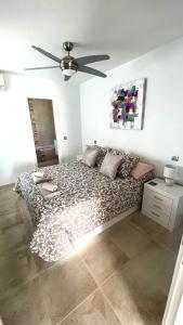 een slaapkamer met een bed en een plafondventilator bij Casa Zen, 1 bedroom apartment on complex with pool, Puerto del Carmen in Puerto del Carmen