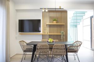 a dining room with a black table and chairs at Inorato - Luxury Villa with Private Swimming Pool in Kalamitsi