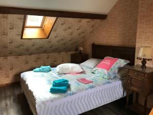ein Schlafzimmer mit einem Bett mit Handtüchern darauf in der Unterkunft Gîte Le Mur magnifique longère au Bourgogne-du-Sud in Oyé
