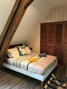 ein Schlafzimmer mit einem Bett im Dachgeschoss in der Unterkunft Gîte Le Mur magnifique longère au Bourgogne-du-Sud in Oyé