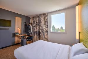 a hotel room with a bed and a window at B&B HOTEL Paris Créteil in Créteil