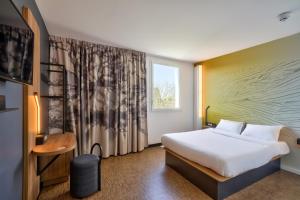 une chambre d'hôtel avec un lit et une fenêtre dans l'établissement B&B HOTEL Paris Créteil, à Créteil