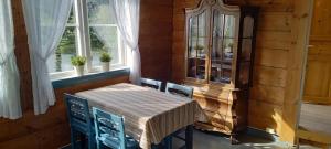 uma sala de jantar com mesa, cadeiras e janelas em Vassel gård em Herand