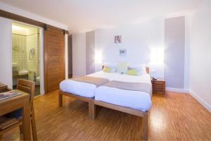 a bedroom with a large bed and a bathroom at Domaine De Barres in Langogne