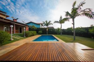 una piscina en una terraza de madera junto a una casa en Linda Casa de Campo - Próximo à SP - Wi-Fi grátis, en Bom Jesus dos Perdões