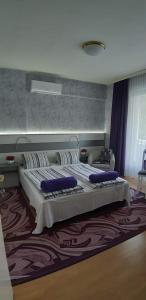 1 dormitorio con 1 cama grande con almohadas azules en Lila Ház, en Harkány