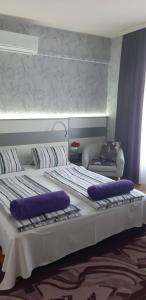 a large bed with purple pillows on top of it at Lila Ház in Harkány