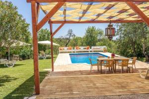 un patio con mesa y sillas junto a una piscina en Einzigartige Landhaus-Villa mit Privat-Pool, en Boliqueime