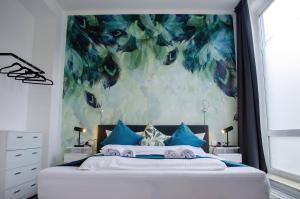 um quarto com uma cama grande e almofadas azuis em HOMELY STAY Studio 6 em Munique