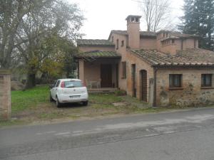 a white car parked in front of a house at La Civetta in Torrita di Siena