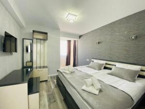 a bedroom with a large bed with white pillows on it at Besami Hotel in Stepantsminda