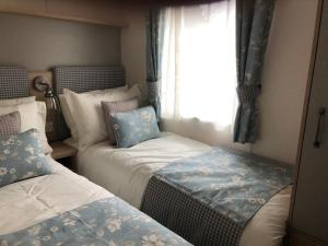 a bedroom with two beds and a window at Luxury 2 bedroom caravan in stunning location in Pitlochry
