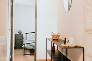 een slaapkamer met een spiegel, een tafel en een bed bij La Casa de Pipo Au cœur de Sarlat in Sarlat-la-Canéda +11 foto's