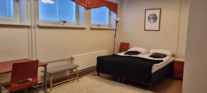 a bedroom with a bed and a desk and windows at Apartments Puistokatu in Savonlinna