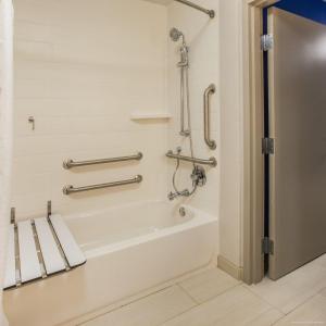 阿皮納的住宿－阿爾皮納市中心智選假日套房酒店，一间带浴缸和淋浴的浴室