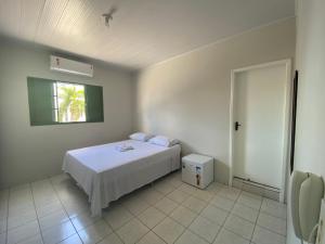 a bedroom with a white bed and a window at Hotel Bianchi in Primavera do Leste