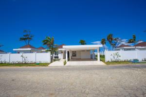 a house with a white fence and a driveway at Ocean Village Deluxe Resort & Spa in Sosúa