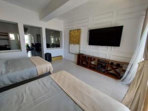 a bedroom with two beds and a flat screen tv at Casa Blanca Grand in Acapulco