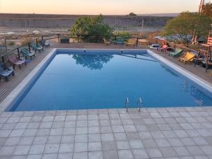 a swimming pool with two people standing in the water at CABAÑAS EL CERRO in Ciudad Lujan de Cuyo