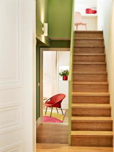 a staircase in a house with a red chair at Hotel des Galeries in Brussels