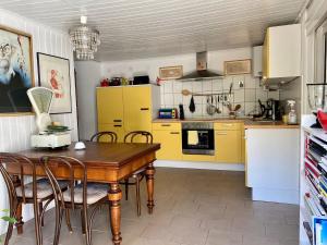 a kitchen with a wooden table and yellow cabinets at HAUS MIT KUNST ZWISCHEN WALD UND SEE in Leipzig