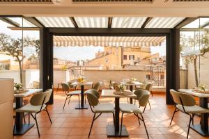 - un restaurant avec des tables, des chaises et de grandes fenêtres dans l'établissement Sonder Piazza di Spagna, à Rome