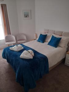 a bedroom with a large bed with towels on it at Tregella Guest House in Newquay