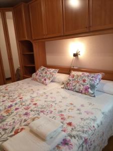 a bed with a floral bedspread and two pillows at Xotola in Elizondo