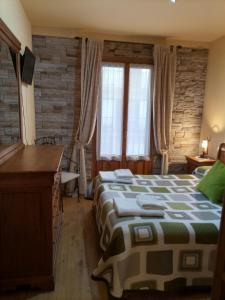 a bedroom with a bed and a desk and windows at Xotola in Elizondo