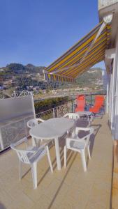 een witte tafel en stoelen op een balkon met uitzicht bij Eden 96 in Camporosso