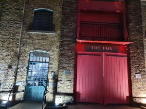 two red doors on the side of a brick building at SNG Apartments Excel in London