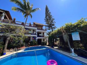 a pool in front of a house with a palm tree at Casa Terranova in Puerto Escondido
